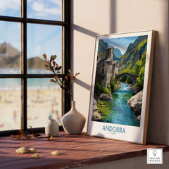 Andorra Old Town River Bridge Art Print | Pyrenees Architecture Poster displayed on a wooden table by the window.