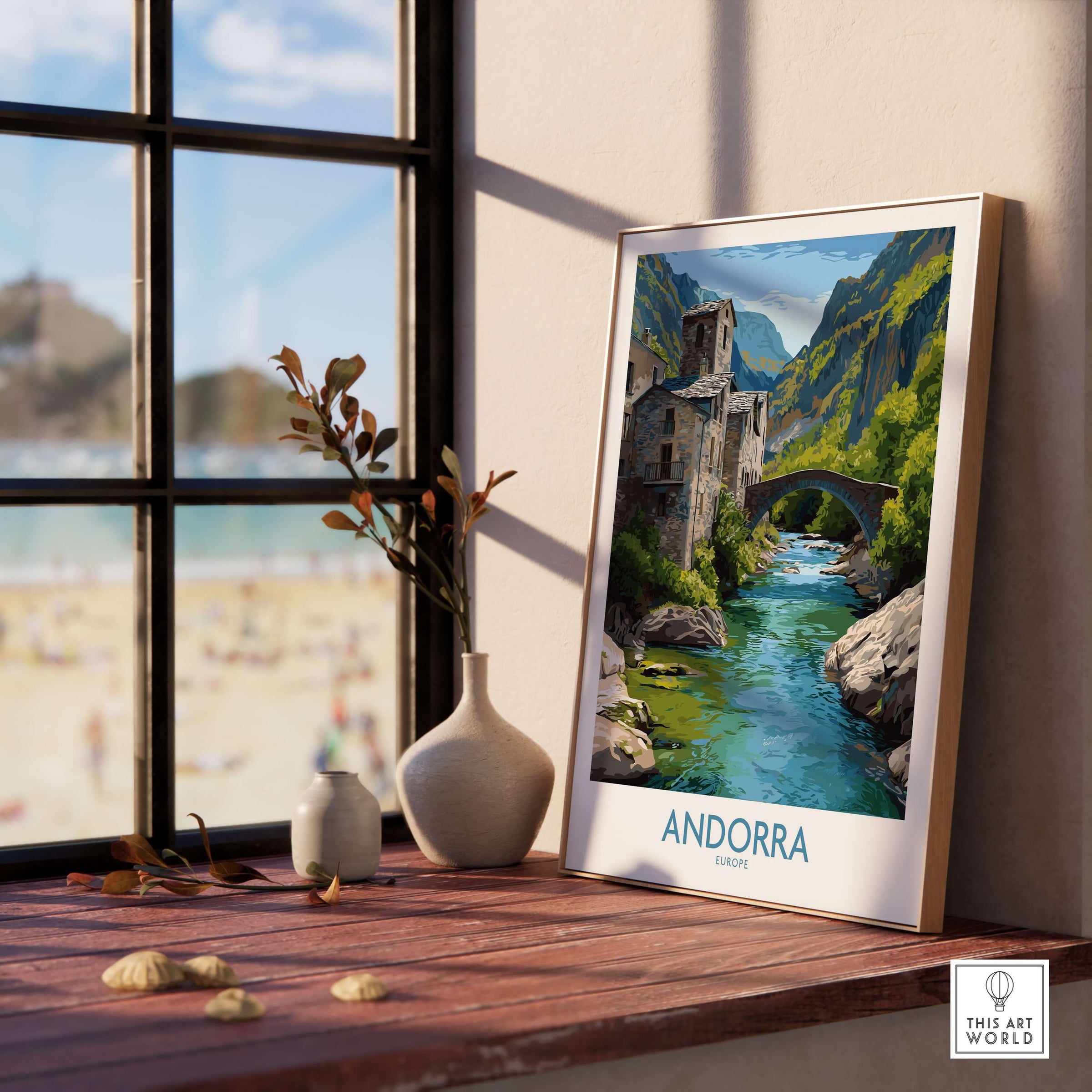 Andorra Old Town River Bridge Art Print | Pyrenees Architecture Poster displayed on a wooden table by the window.