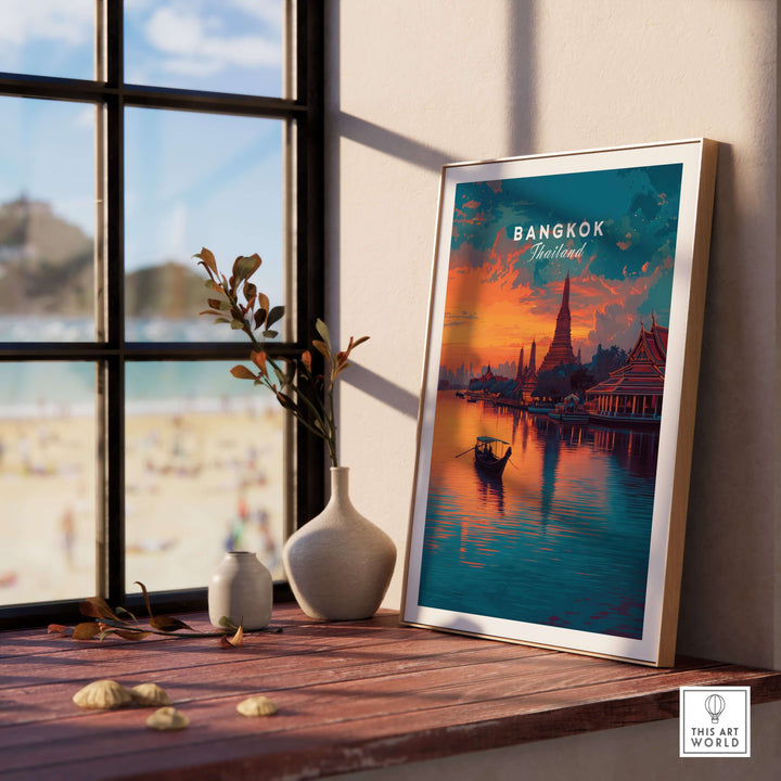 Wat Arun sunset reflection print in a framed art piece on a wooden table in a sunny room.