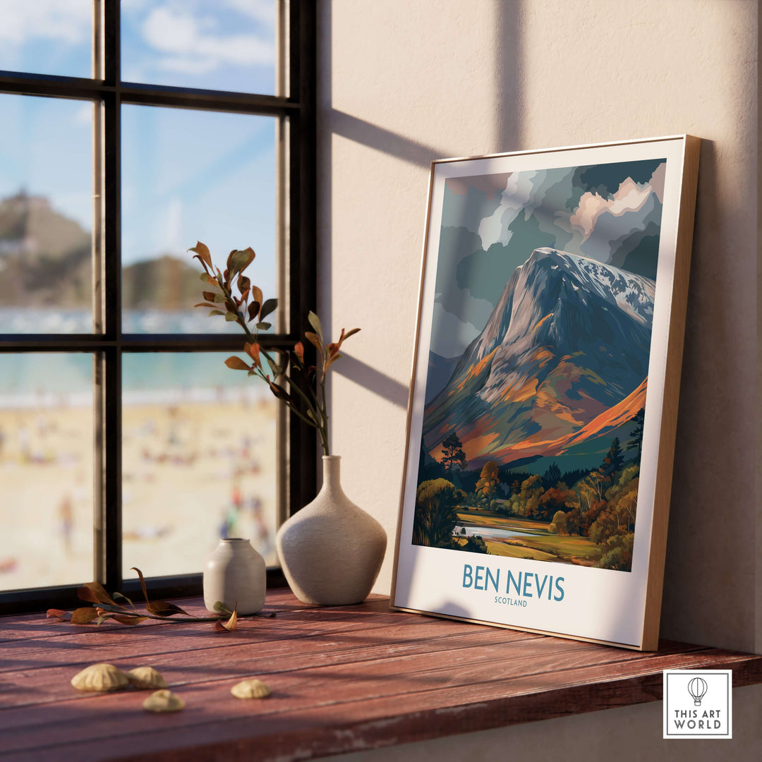 Framed print of Ben Nevis in Scotland displayed by a window, capturing the mountain's cloudy majesty and rugged beauty.