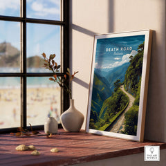 Death Road Andes Print | Yungas Road Poster displayed on a wooden table by a window with a scenic view.