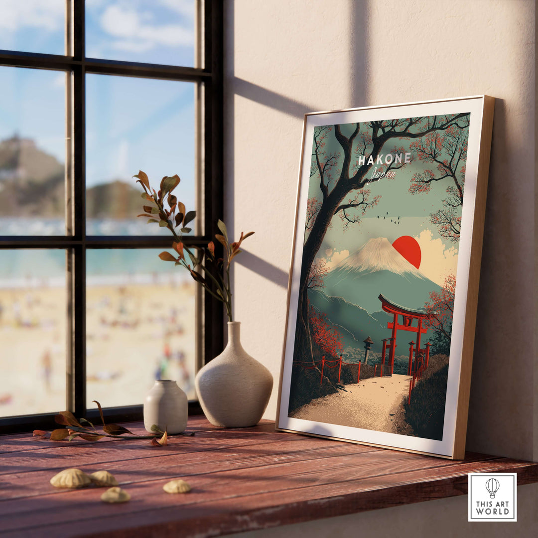 Hakone Japan Torii gate print with Mount Fuji in a framed artwork on a wooden table by a window.