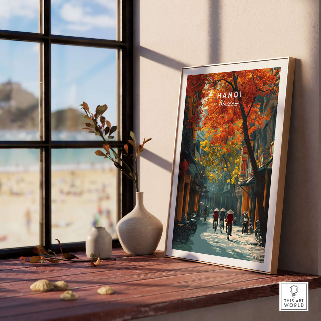 Hanoi poster featuring vibrant autumn colors and street scene in a framed display by a sunny window.