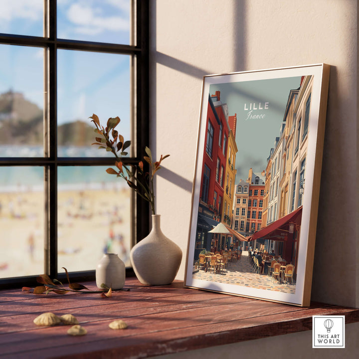 Lille France street scene print in a stylish frame near a sunny window, showcasing vibrant architecture and outdoor dining.