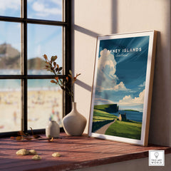 Orkney Islands Coastal Cottage Print - Green Hills Scotland Poster displayed on a wooden table with a coastal view.