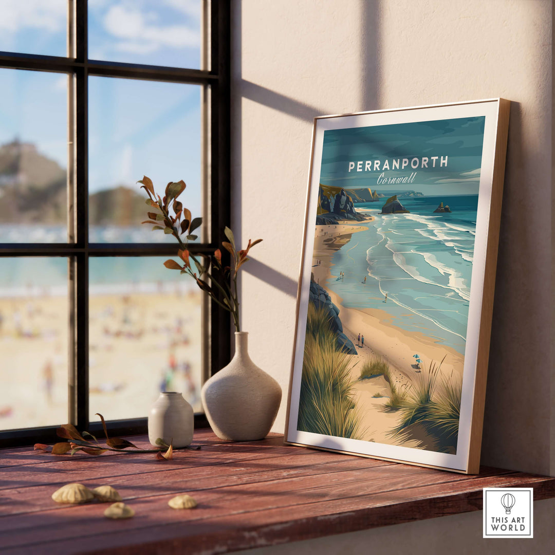 Framed print of Perranporth Cornwall beach dunes on a windowsill, showcasing coastal wall art decor.