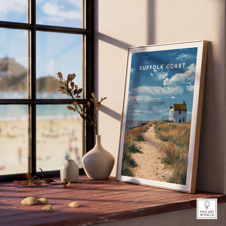 Framed Suffolk Coast seaside print showcasing coastal pathway and beach scene with decorative vase on windowsill.