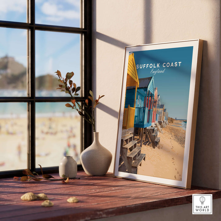 Colorful beach huts poster on a wooden table, showcasing Suffolk Coast England's sandy shoreline.