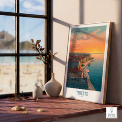 Trieste Italy Wall Art - Italian Evening Poster displayed on a wooden table near a window with a beach view.