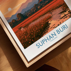 Suphan Buri Thailand Temple Sunset Wall Art — a lotus-covered lake and temple spire at sunset beneath a mountain peak, shown as closeup framed canvas natural wood floating frame