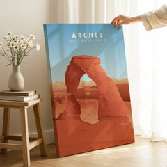 Hand holding Arches National Park canvas print in modern room with natural light and flowers