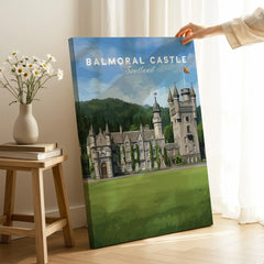 Hand holding Balmoral Castle Scotland travel poster canvas in bright living room setting