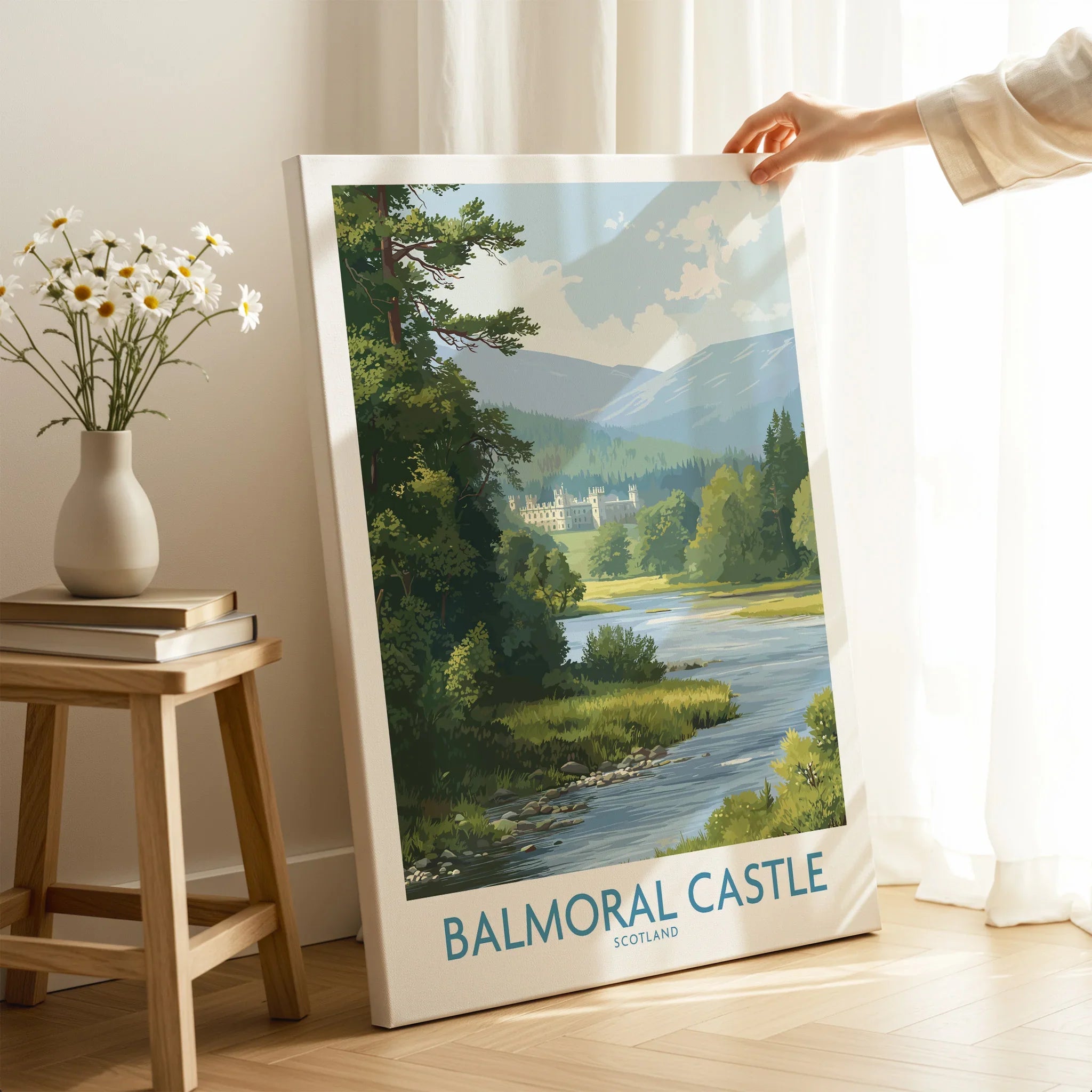 Hand holding Balmoral Castle Scotland travel poster canvas print in bright modern room