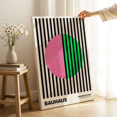 Bauhaus Exhibition Prints - Split Circle Abstract Art Print Pink Green Stripes displayed in an artistic setting with flowers.