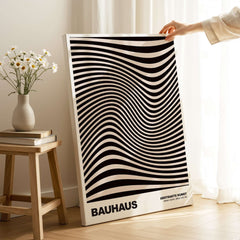Bauhaus Exhibition Prints -  Optical Wave Lines Art Print Black Cream Abstract displayed in a bright room with a flower vase.