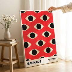 Bauhaus Exhibition Prints - Repeating Eyes Pattern Poster Red Black Cream Art displayed in a modern interior setting.