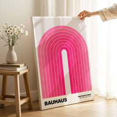 Bauhaus Exhibition Prints - Concentric Pink Arch Poster Minimalist Geometric Art displayed on a stand with flowers.