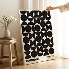 Bauhaus Exhibition Prints - Geometric Circle Shapes Art Print Black White Pattern displayed on a wooden table with flowers.