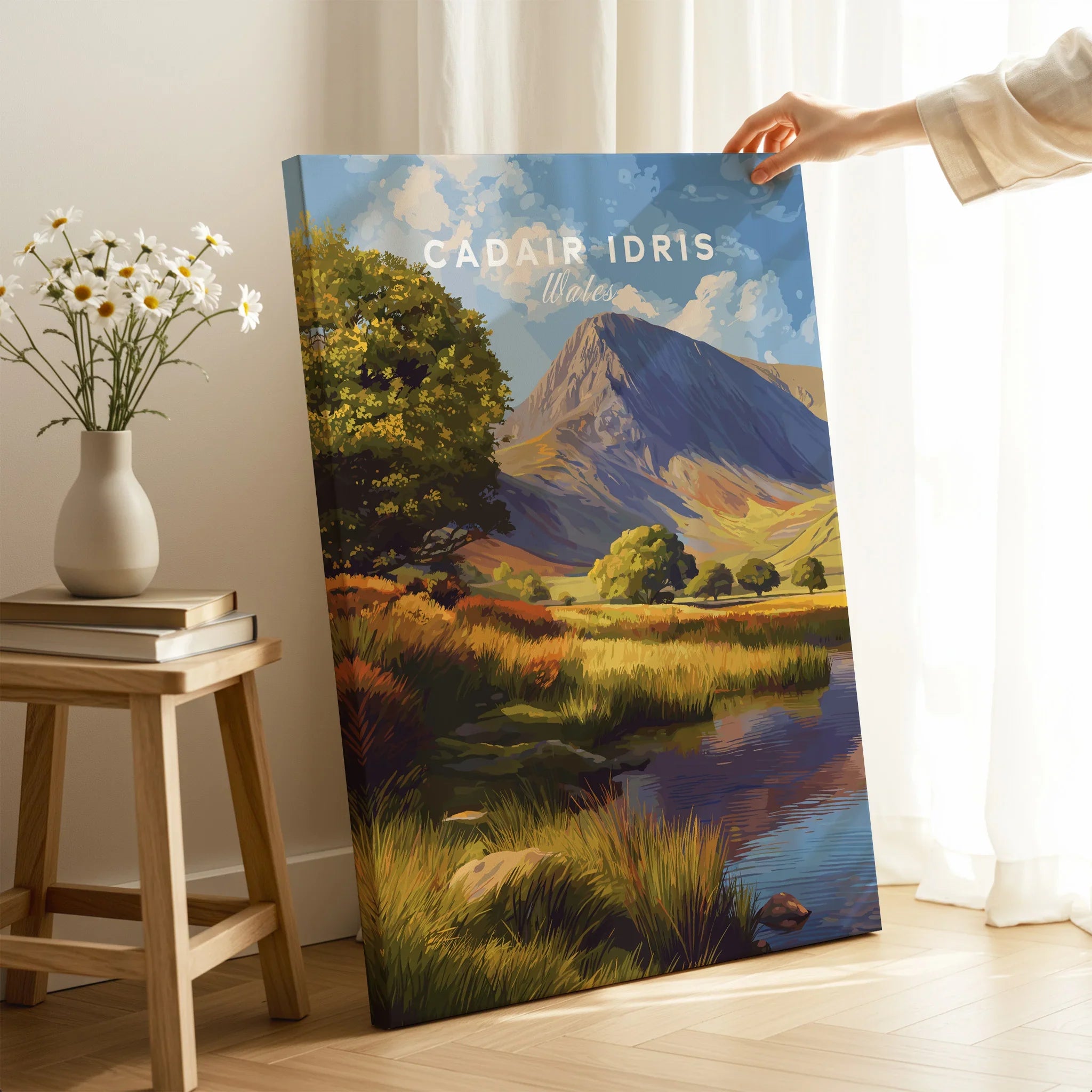 Hand holding a canvas print of Cadair Idris Wales landscape art in a cozy room setting