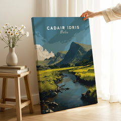 Hand holding a canvas print of Cadair Idris Wales mountain landscape in cozy room setting