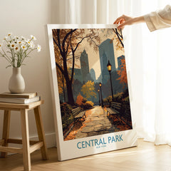 Central Park New York canvas wall art with autumn path and city skyline, hand holding print