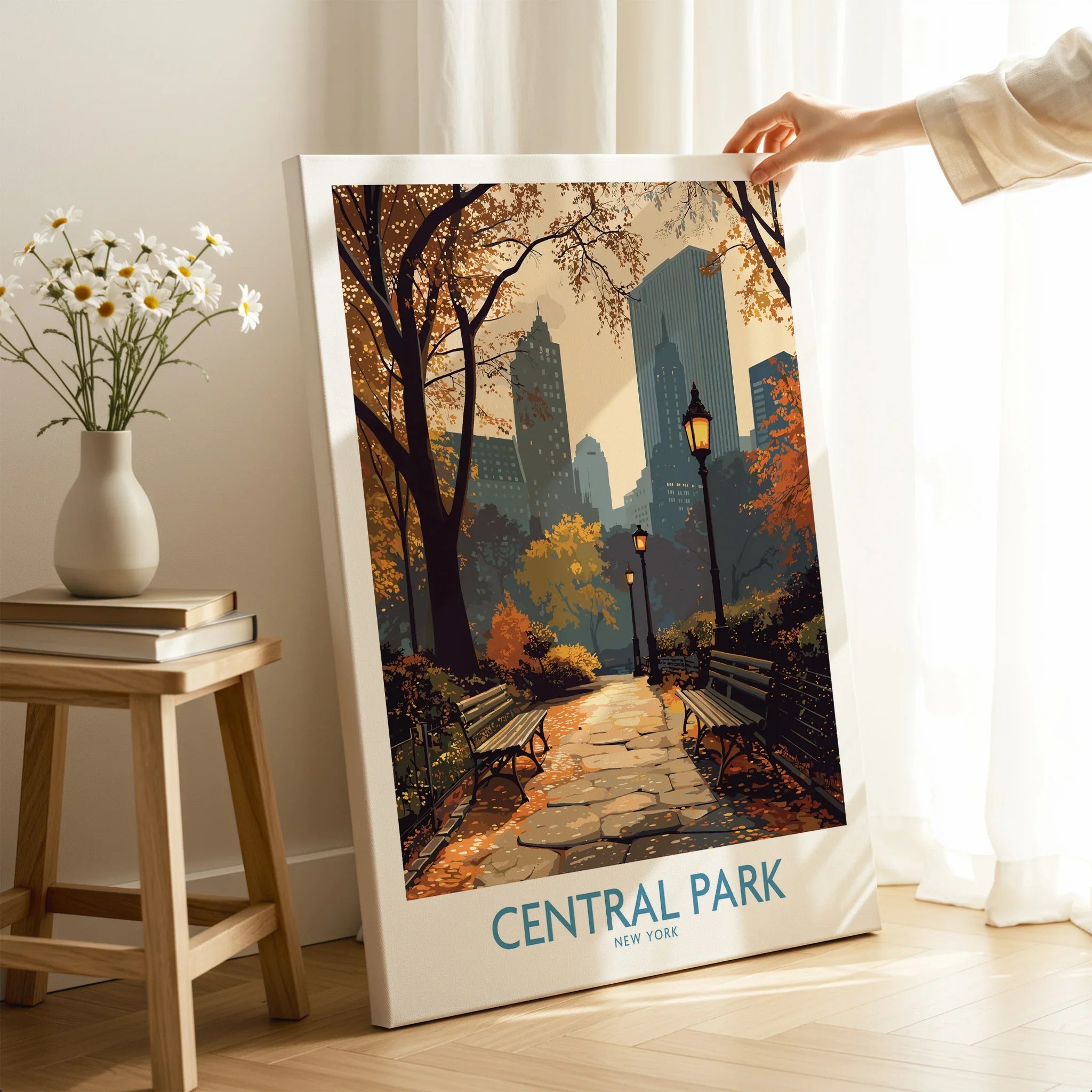 Central Park New York canvas wall art with autumn path and city skyline, hand holding print