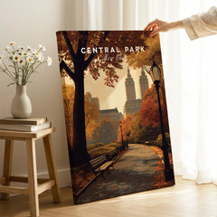 Hand holding Central Park New York canvas print with autumn scene in cozy living room