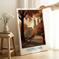 Hand holding Central Park New York canvas print with autumn trees in cozy home setting