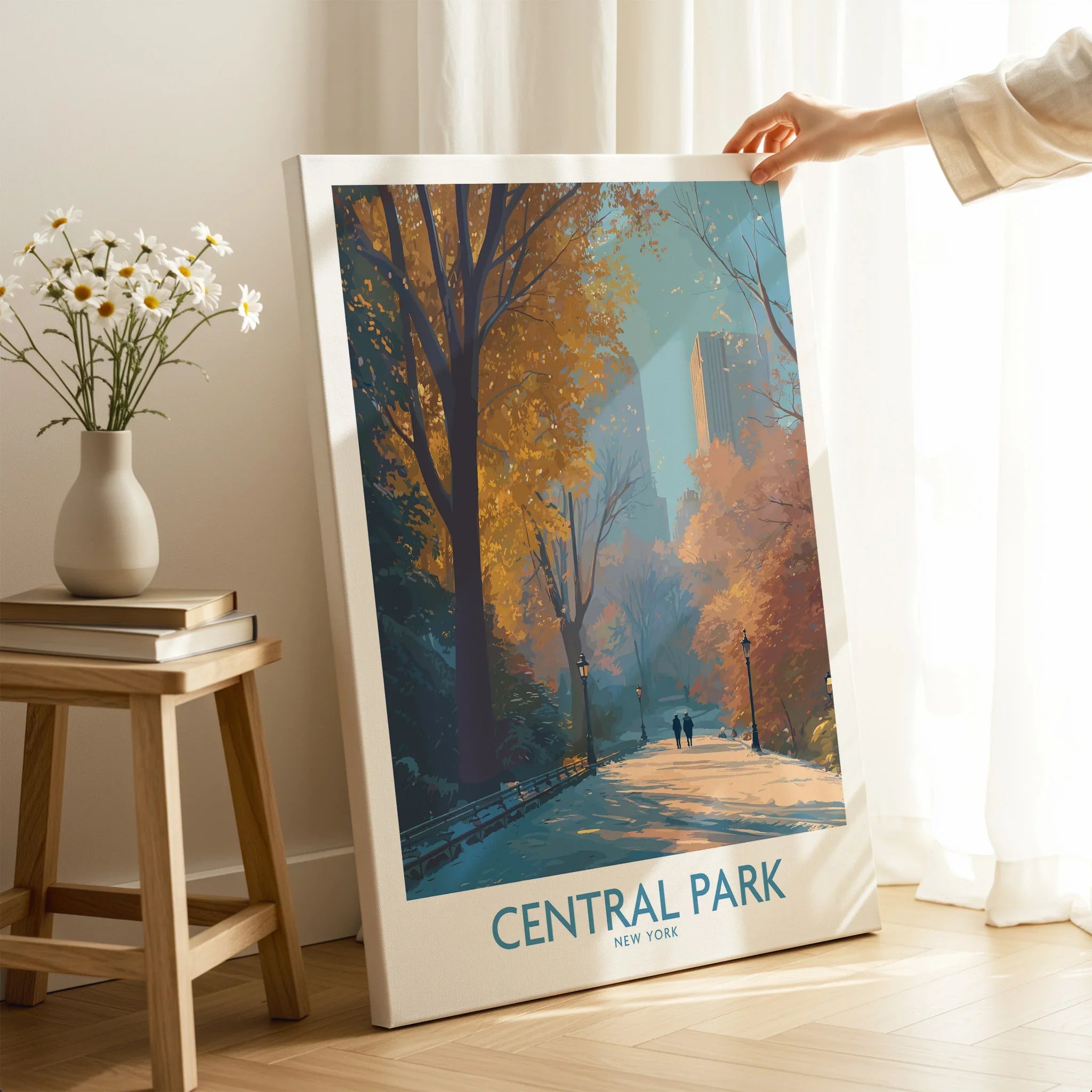 Hand holding Central Park New York canvas wall art with autumn trees in a cozy room