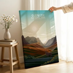 Hand holding Glencoe National Park canvas wall art with scenic mountain landscape in a cozy room