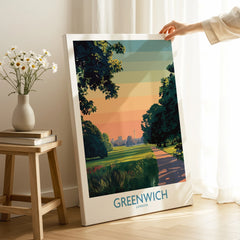 Hand holding Greenwich London travel poster canvas in sunlit room, modern wall art decor