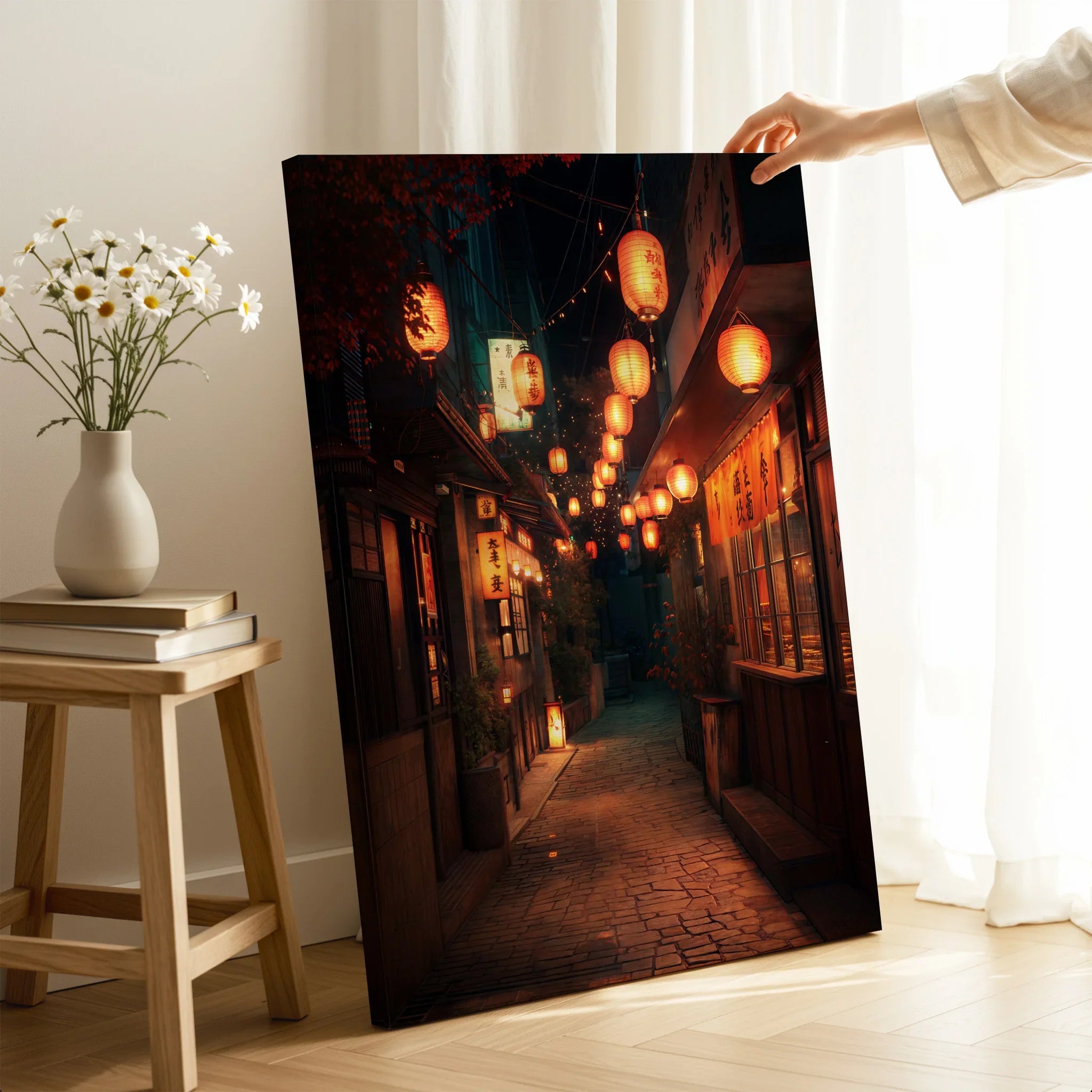 Hand holding Japanese street scene canvas print with lanterns in modern home decor setting