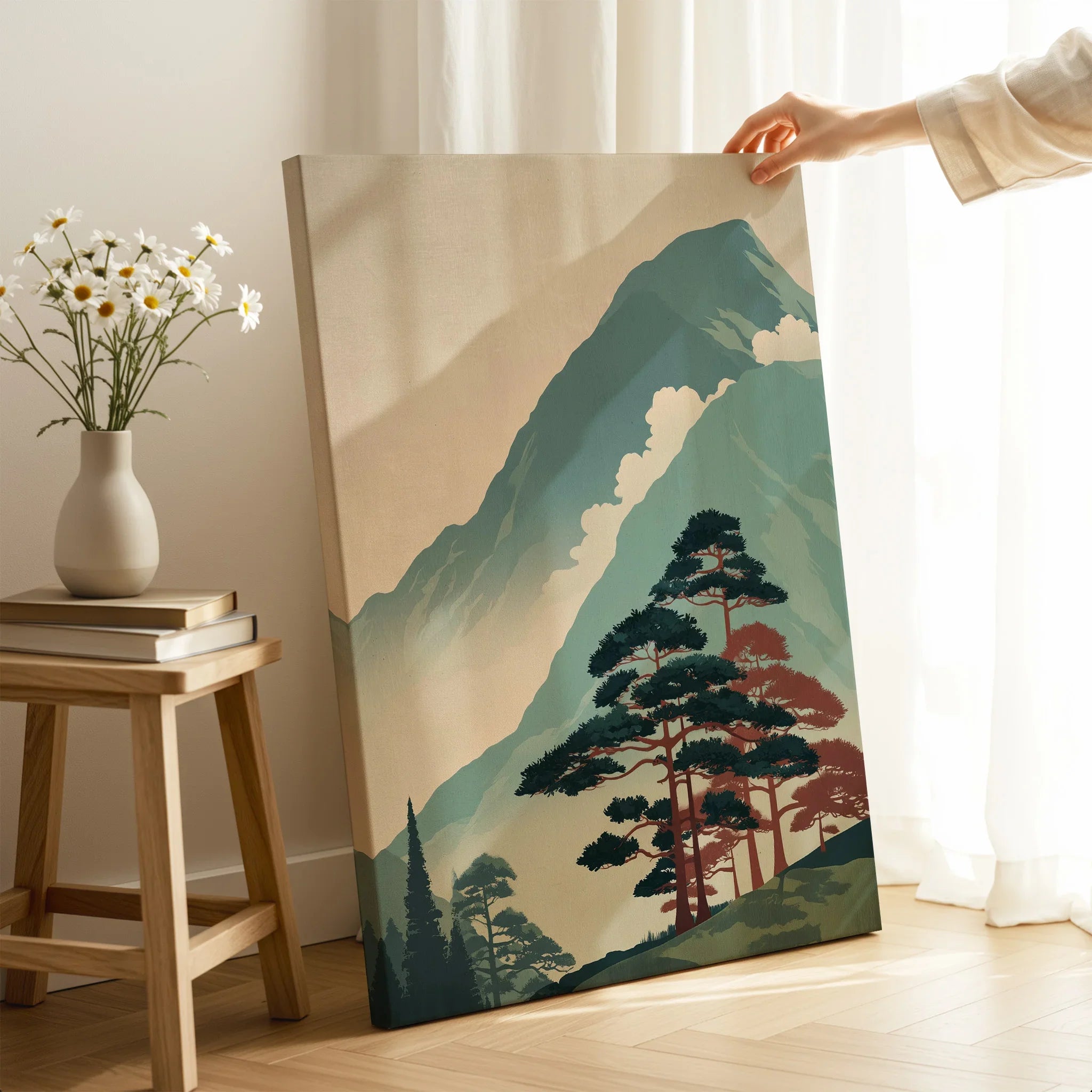 Hand holding a Japanese woodblock canvas print with mountain and tree landscape in a cozy room