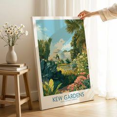 Hand holding Kew Gardens botanical wall art print in a bright room with flowers and books