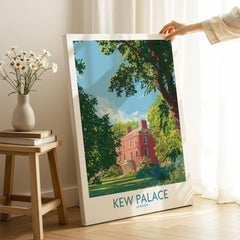 Hand holding Kew Palace London canvas art print in bright home setting with flowers nearby