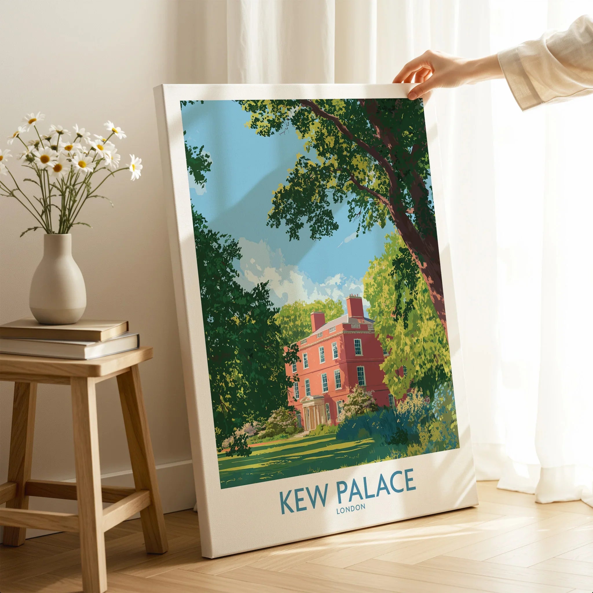 Hand holding Kew Palace London canvas art print in bright home setting with flowers nearby