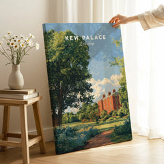 Hand holding Kew Palace London travel poster print in sunlit room with books and daisy vase