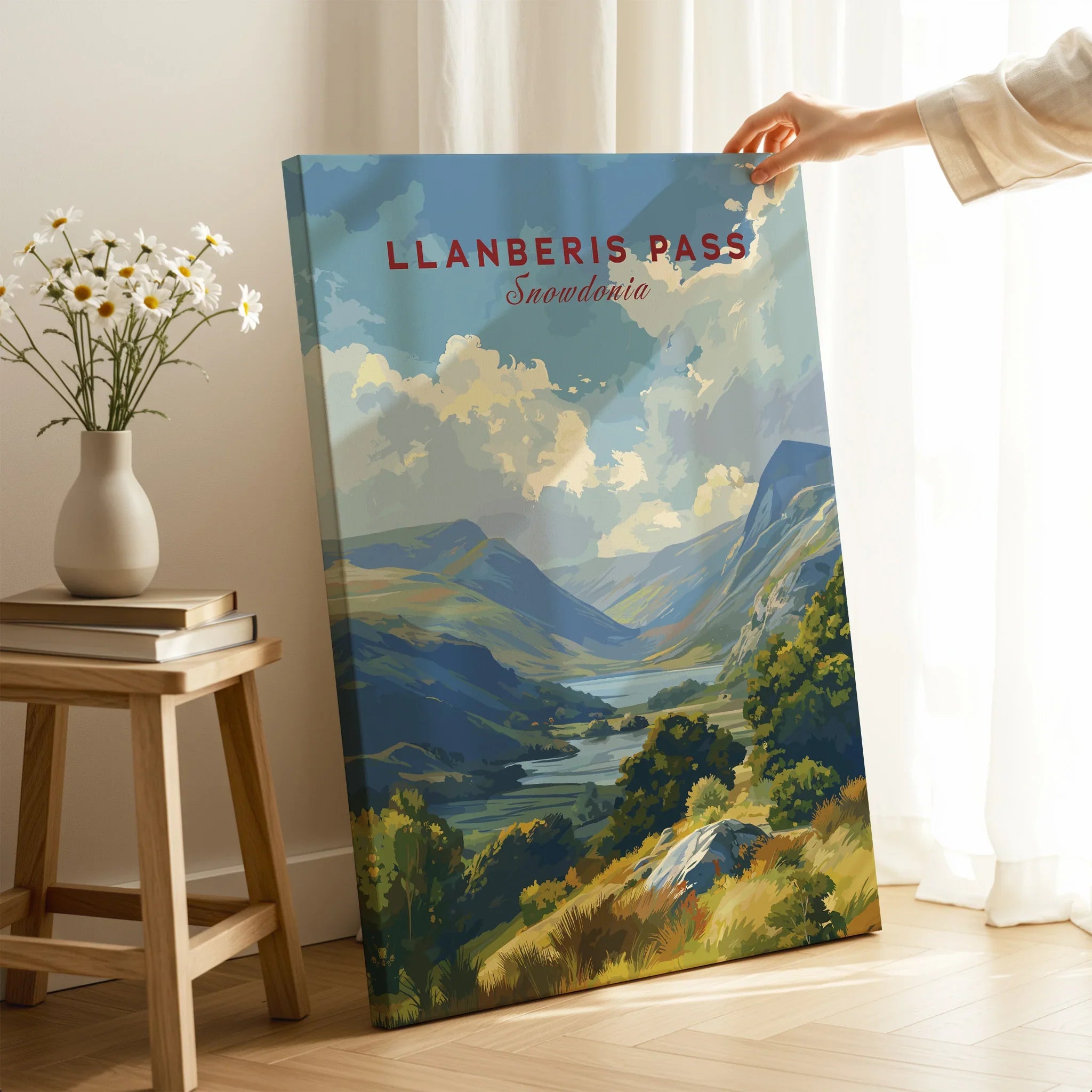 Hand holding Llanberis Pass Snowdonia travel poster canvas in cozy room with natural light