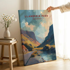 Hand holding Llanberis Pass Snowdonia travel poster canvas print in modern room setting