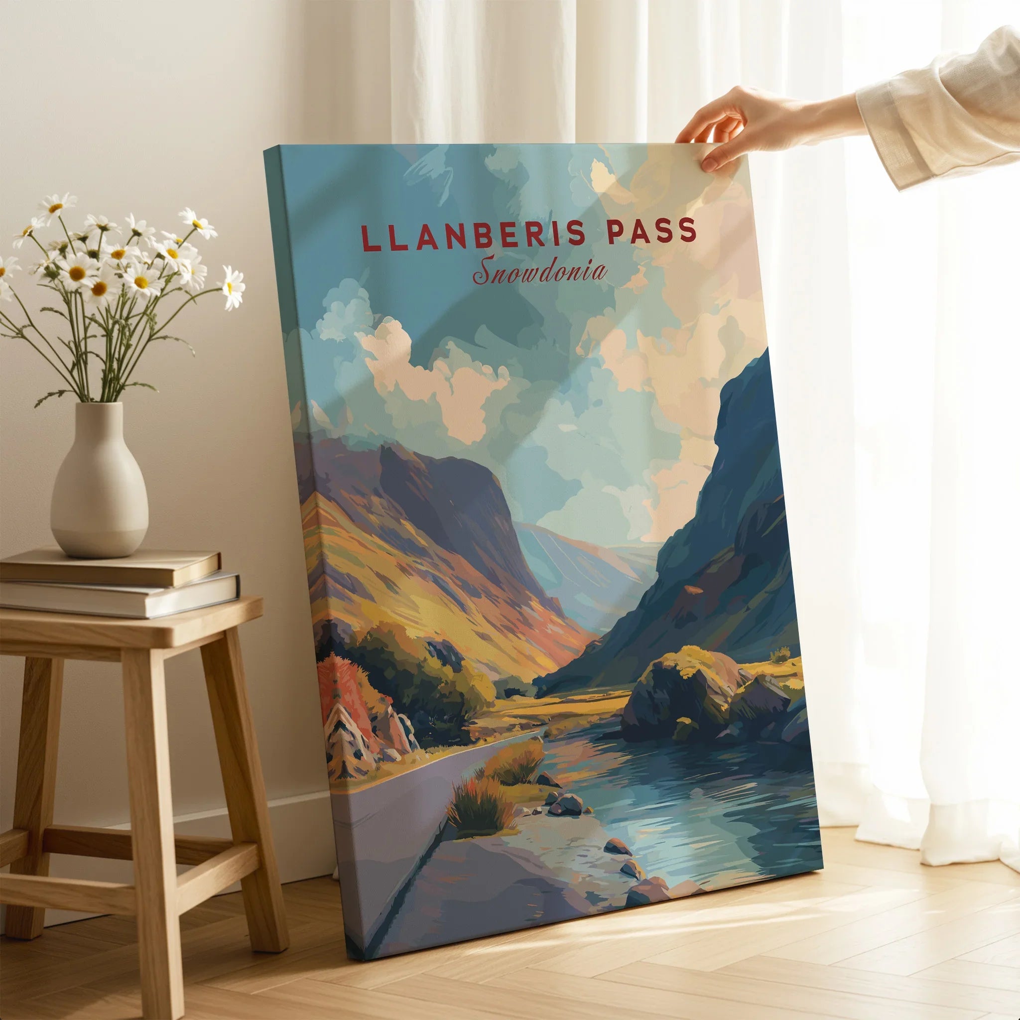 Hand holding Llanberis Pass Snowdonia travel poster canvas print in modern room setting