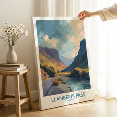 Hand holding Llanberis Pass Snowdonia travel poster print in cozy room with natural light