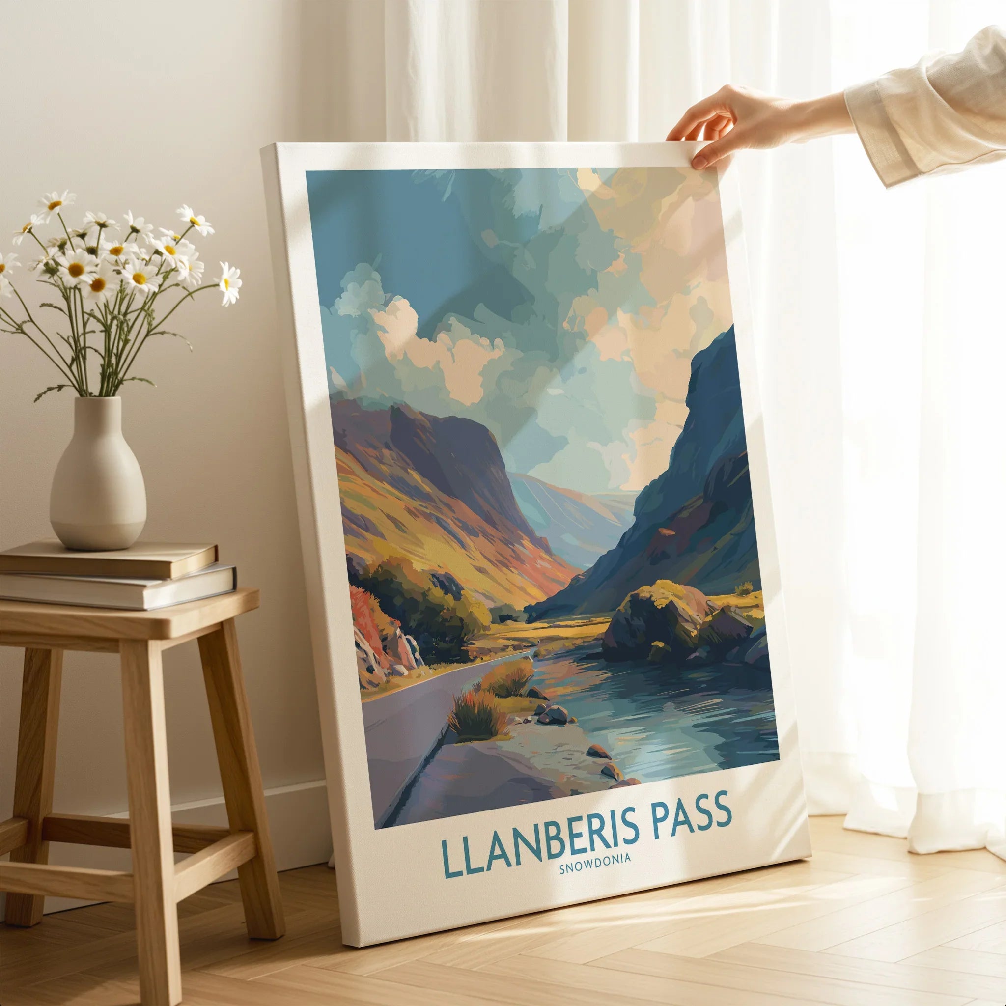 Hand holding Llanberis Pass Snowdonia travel poster print in cozy room with natural light