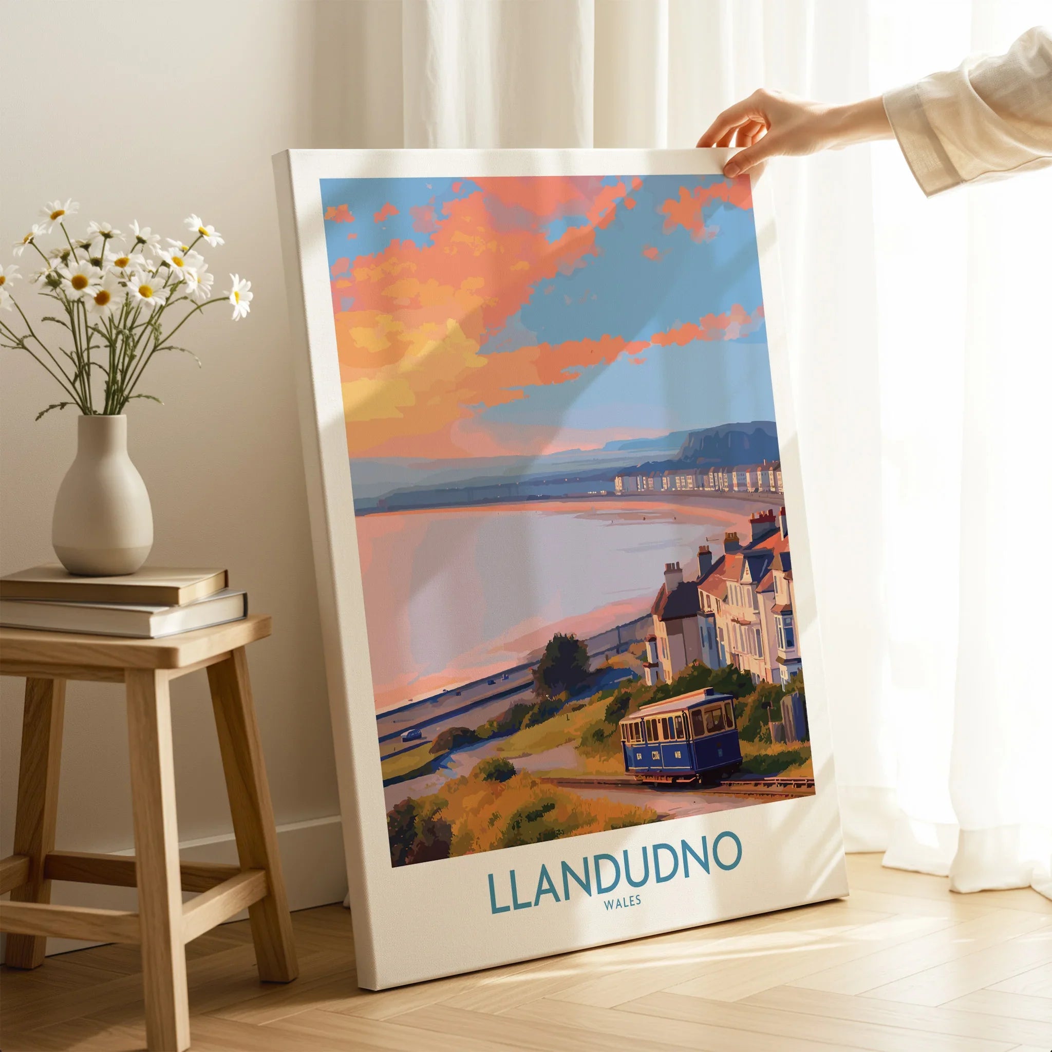 Llandudno Wales canvas travel poster with tram, coastal view, and colorful sunset, in home decor setting