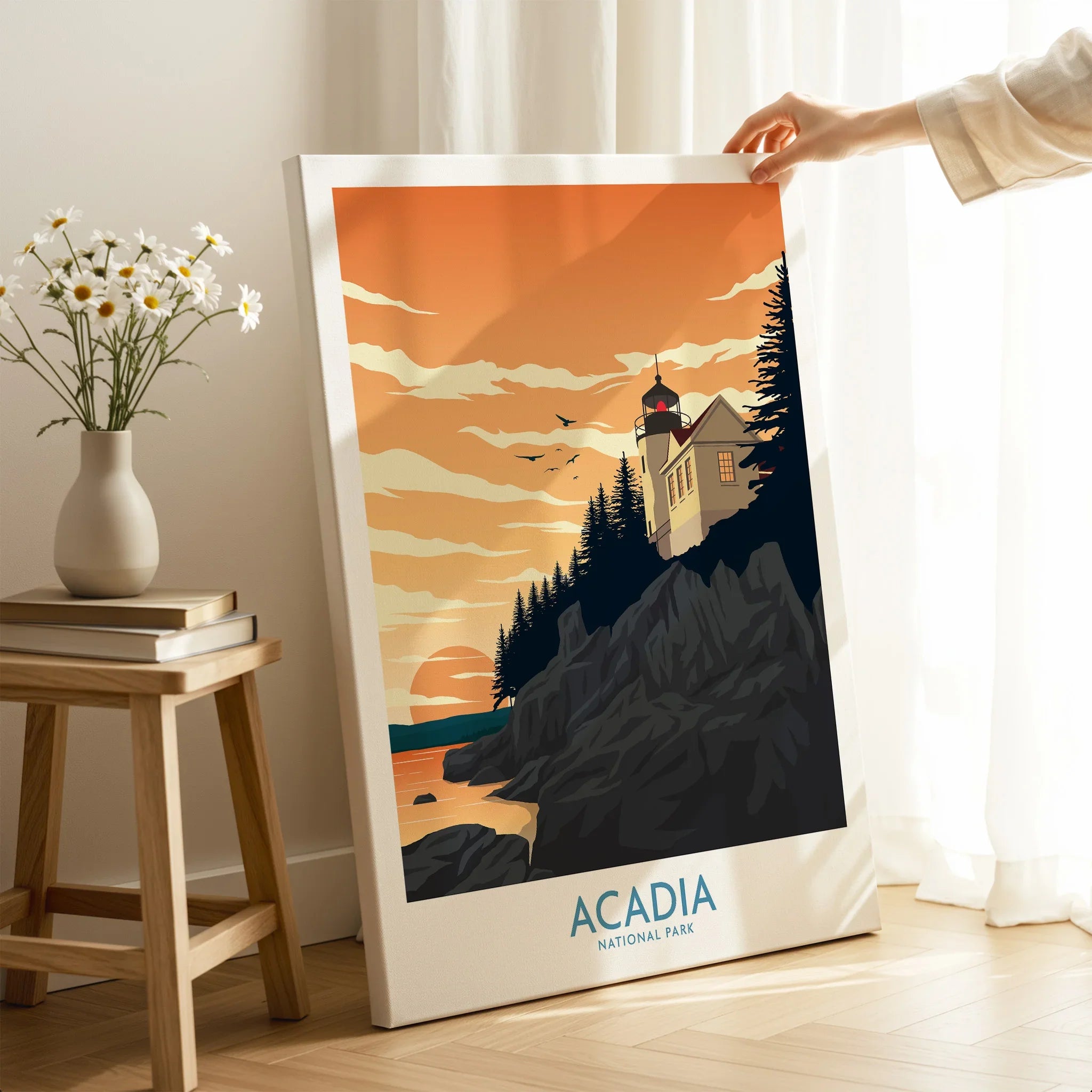 Hand holding Acadia National Park canvas print with lighthouse sunset art in cozy room