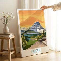 Hand holding Glacier National Park canvas print with mountain landscape in sunny room