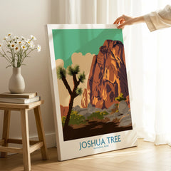 Hand holding Joshua Tree National Park canvas print in cozy room with sunlight and flowers