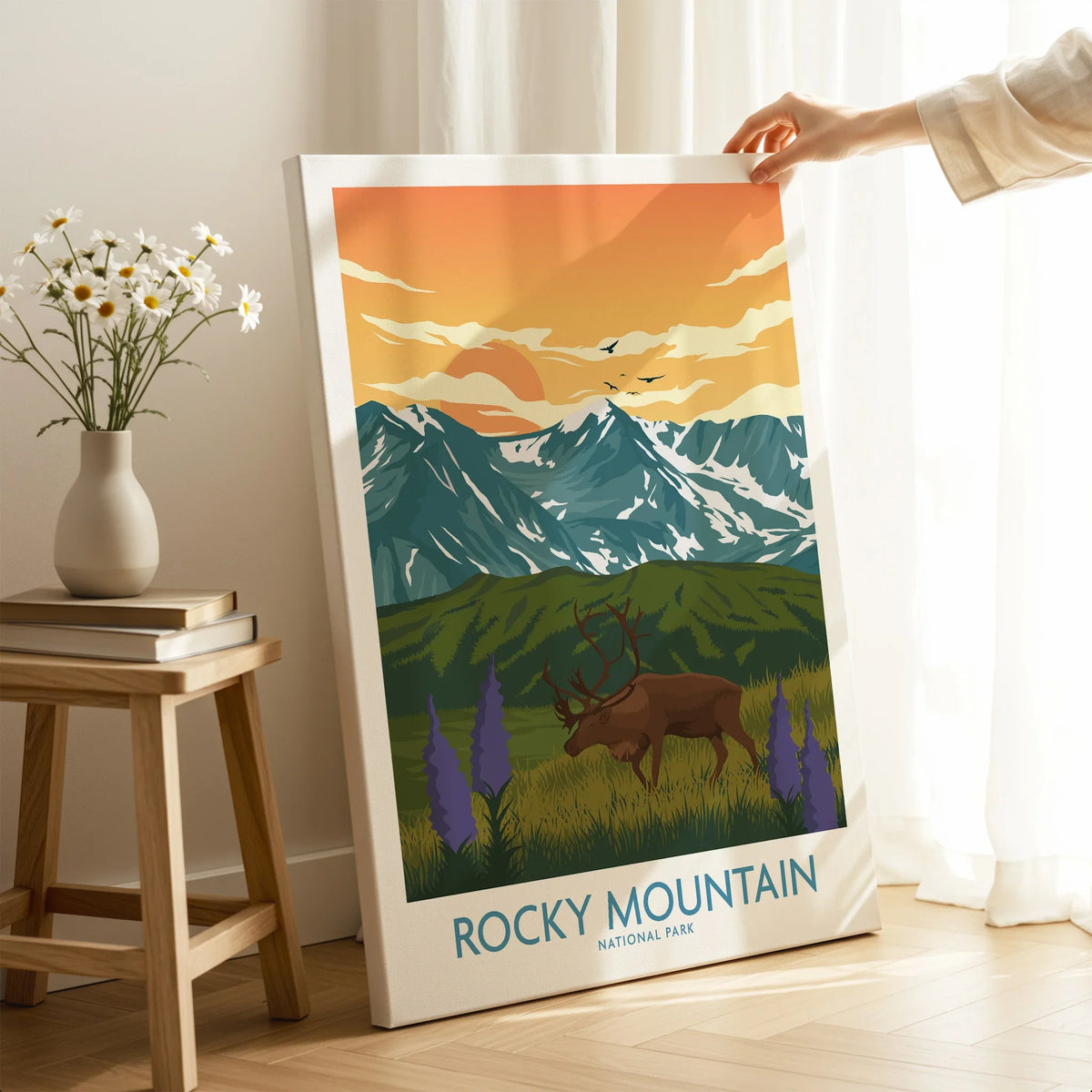 Hand holding Rocky Mountain National Park canvas print with elk and mountain art in room