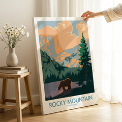 Hand holding Rocky Mountain National Park canvas print with bear and mountain scenery in modern room