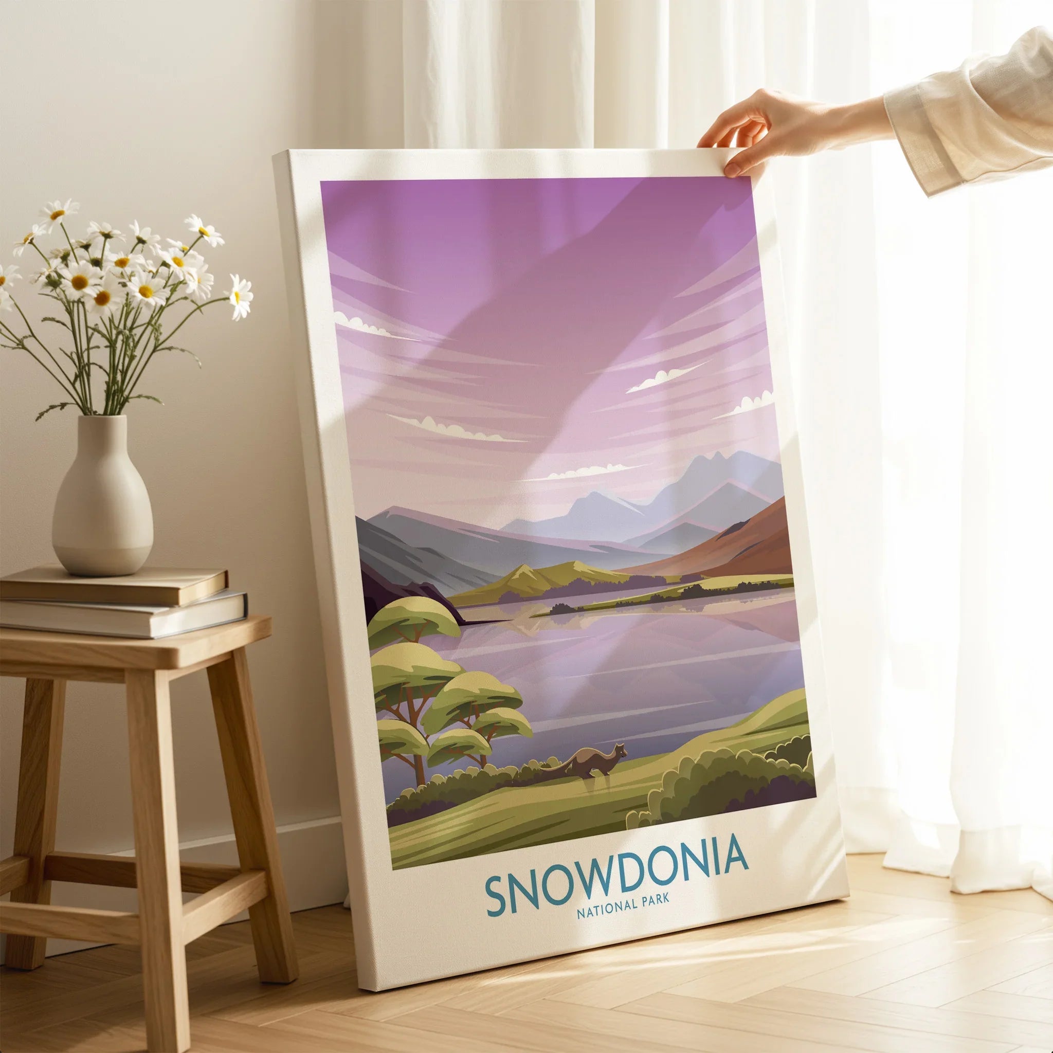 Hand holding Snowdonia National Park canvas print with landscape art in a cozy room setting