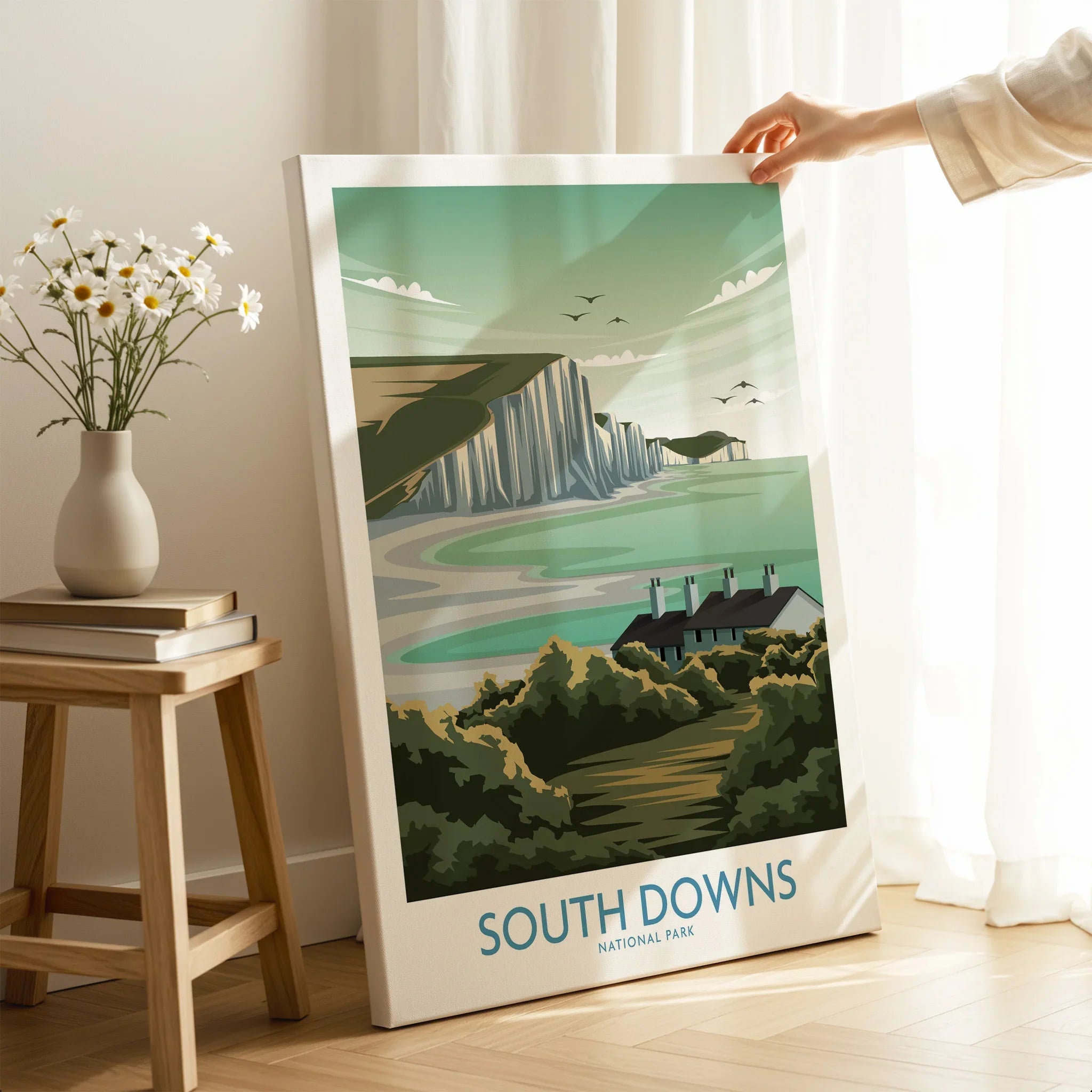 South Downs National Park canvas print with coastal cliffs, held by hand in modern home decor setting